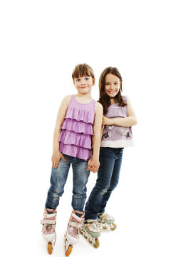 Two Cute Girls Holding Hands Wearing Roller Skates