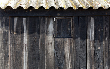 Aged black wood with wavy roof in balearic beach