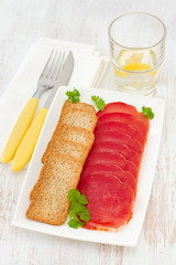 prosciutto with toasts on the white plate