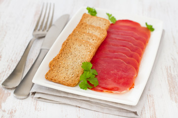 prosciutto with toasts on the white plate