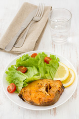 fish with salad and lemon on the white plate