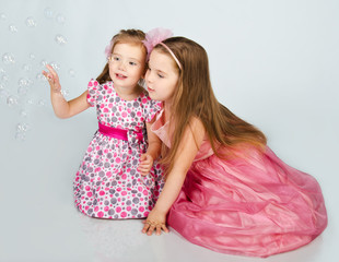 Two cute little girls looking soap bubbles © svetamart