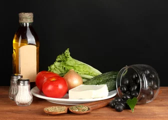 Fotobehang Ingredients for a Greek salad on black background © Africa Studio