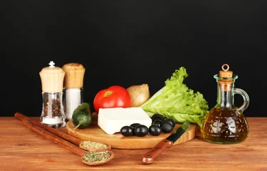 Fotobehang Ingrediënten voor een Griekse salade op zwarte achtergrond © Africa Studio