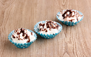 Creamy cupcakes on wooden background