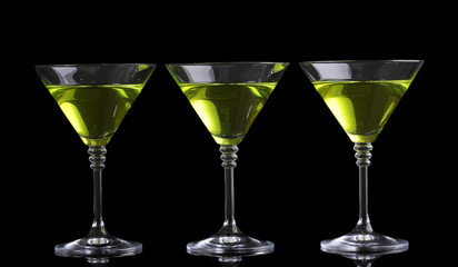 Yellow cocktail in martini glasses isolated on black