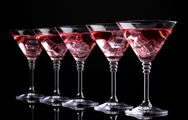 Red cocktail in martini glasses isolated on black