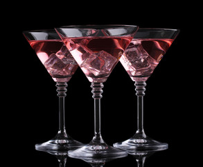 Red cocktail in martini glasses isolated on black