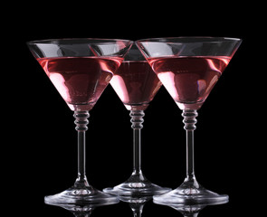 Red cocktail in martini glasses isolated on black