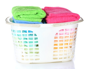 Plastic basket with bright towels isolated on white
