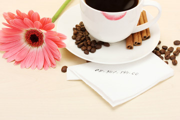 cup of coffee with lipstick mark and gerbera beans, cinnamon