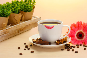 cup of coffee with lipstick mark and gerbera beans, cinnamon