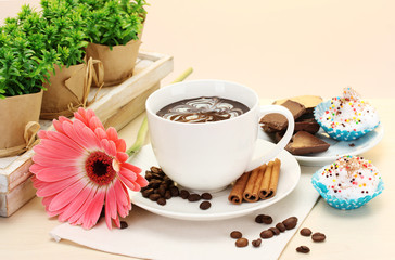 cup of coffee and gerbera  beans, cinnamon sticks
