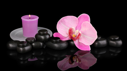 Fototapeta na wymiar Spa stones with orchid flower and candle isolated on black