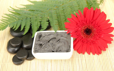 cosmetic clay for spa treatments on straw background close-up