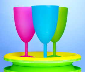 Bright plastic tableware on blue background