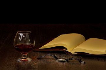 Cognac, cigar and an old book nearby