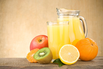 fresh fruits juice in glass and slices on wood