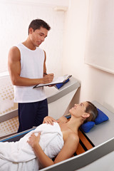 Fitnesstrainer berät Frau in Spa
