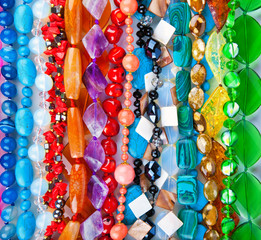 Lot of colored beads from different minerals and stone backgroun