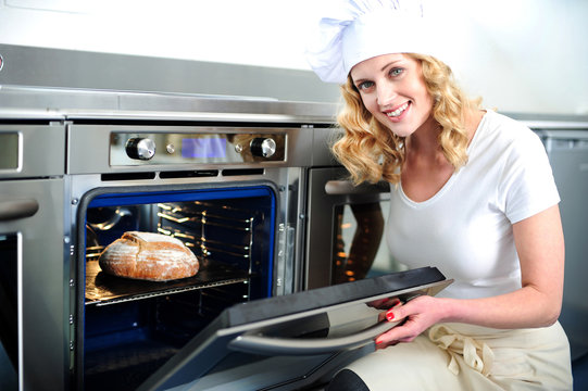 Pretty Baker Opening An Oven Door