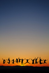Fototapeta na wymiar sylwetka nastolatków skoków w zachodzie słońca dla zabawy