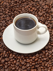 Cup with Hot Coffee on Coffee Beans