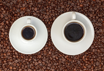 Cups with Hot Coffee on Coffee Beans