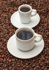 Cups with Hot Coffee on Coffee Beans