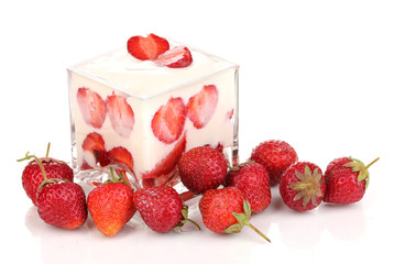 Glass of ripe strawberries with cream isolated on white