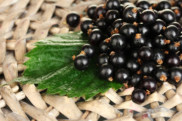 Fresh black currant on wicker mat close-up