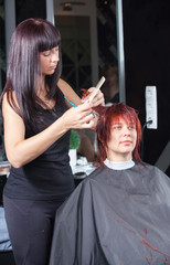 Fototapeta premium hair stylist cutting woman hair in salon