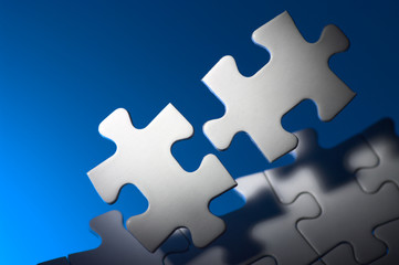 Obraz premium Fitting puzzle pieces in spot light.