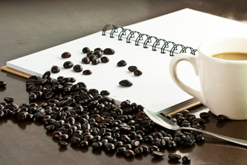 Cup of coffee and coffee beans,note book paper blank