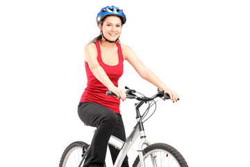 Fototapeta premium Female biker with helmet posing next to a bike