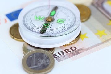 euro coins, euro banknote and compass