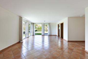 room with terracotta floor, windows overlooking the garden