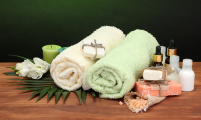 Spa setting on wooden table on green background