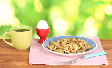 Fried zucchini with eggs and coffee for breakfast