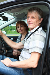 Mature husband and wife sitting in land vehicle