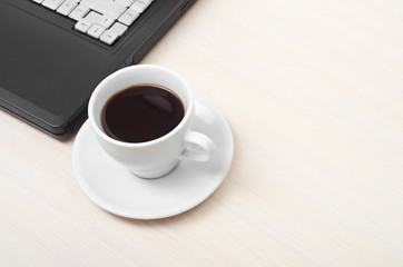 laptop with fresh cup of coffee and notebook, view from above