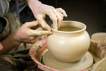 hands of a potter, creating an earthen jar on the circle
