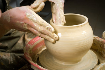 hands of a potter, creating an earthen jar on the circle