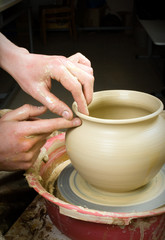 hands of a potter, creating an earthen jar on the circle