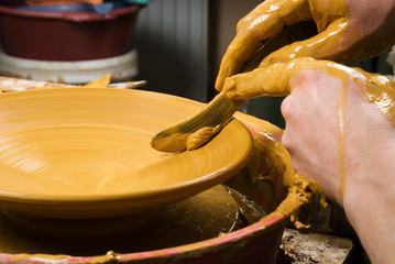 hands of a potter, creating an earthen jar