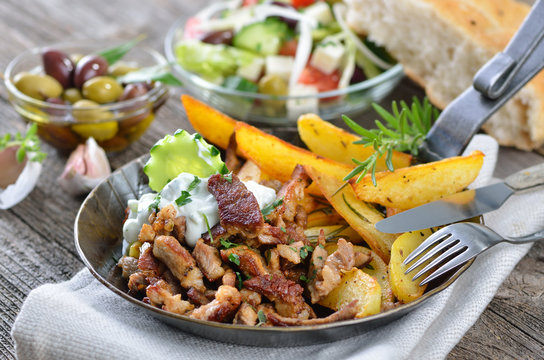 Deftige Gyrospanne mit Bauernsalat, Pitabrot und Oliven