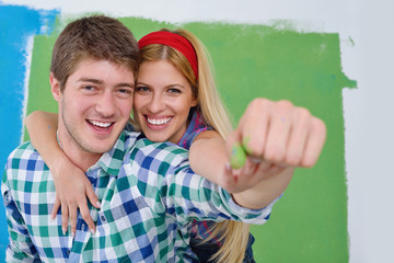 happy couple paint wall at new home