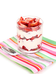 Glass of ripe strawberries with cream isolated on white