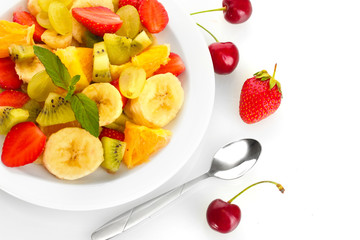 Fresh fruits salad on plate and berries isolated on white