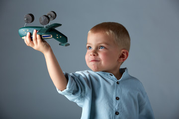 young boy with wooden airplane
